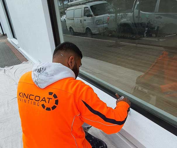 Image of a man wearing an orange uniform choosing a paint colours