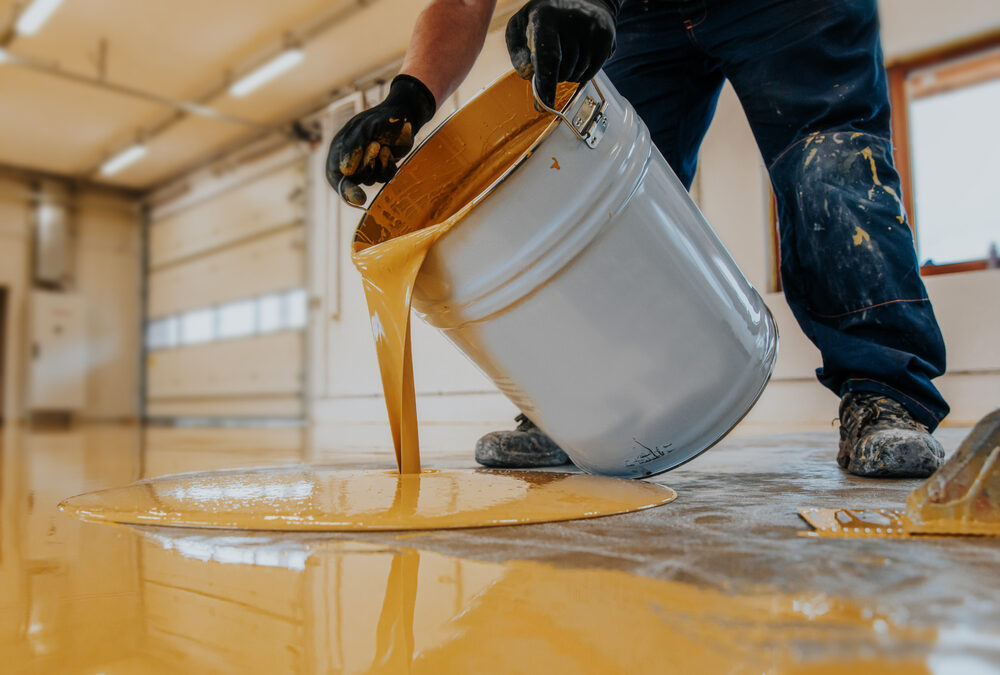 Image of a person pouring epoxy floors into a bucket